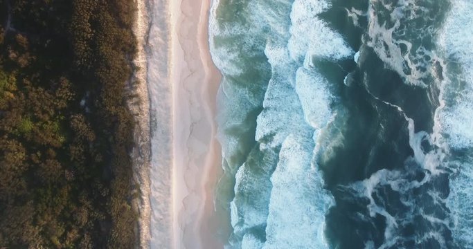 Aerial Drone Shot Top View of Ocean Waves, Beach and Grass Moving Down the Beach