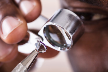 Jeweler Examining Diamond Through Loupe
