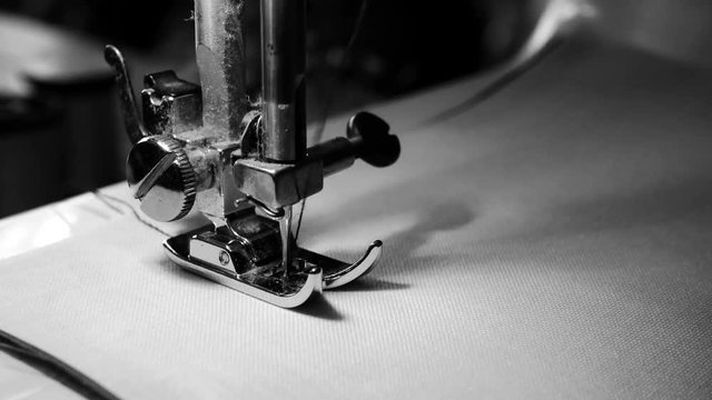 4K footage. close up of sewing machine needle on white fabric with slow motion , black and white color
