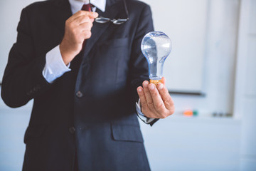 Naklejka premium Senior business man holding light bulb.