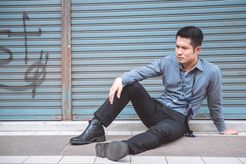 Unemployed man sitting on the street