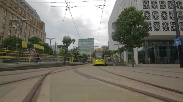 SLOW Motion footage moving along metro tram line in Manchester towards yellow metro tram.