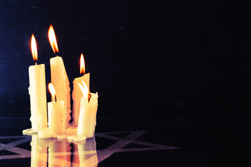 Six burning candles and the Star of David, against a  background.