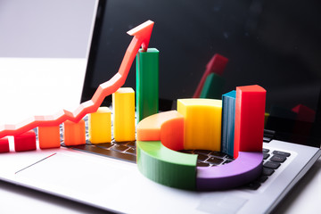 Close-up Of Two Different Charts And Laptop