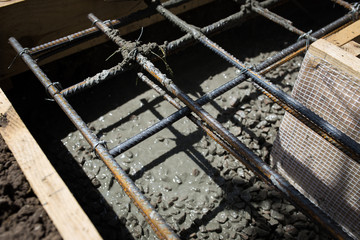 Close up wire mesh and wet cement in concrete floor pouring process
