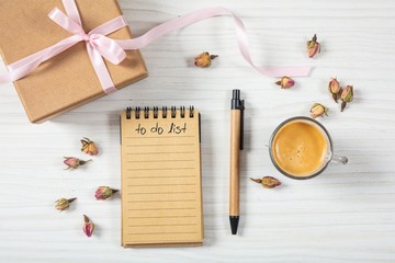 Flat lay and top view of gift box, invitations and check list on a white wooden tabletop, background, blank space.