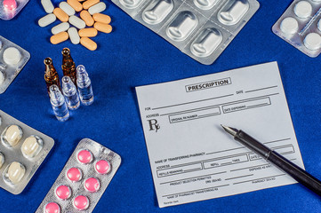 prescription, pen, tablets and ampoules on a blue velvet background