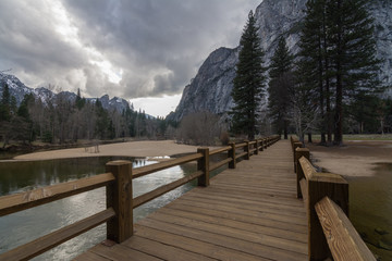 Obraz premium Wooden pathway on pond among mountains