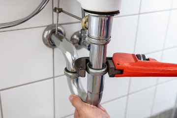 Plumber Repairing Sink With Adjustable Wrench