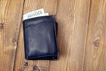 old black purse on a wooden table
