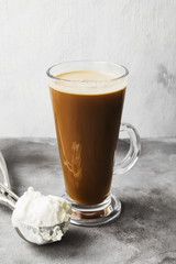 Ice coffee with ice cream on gray background