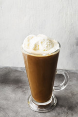 Ice coffee with ice cream on gray background