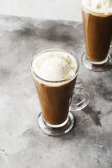 Ice coffee with ice cream on gray background