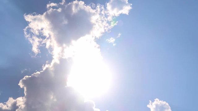 Clouds reveal the sun on the blue sky - timelapse