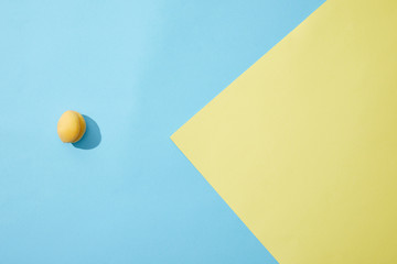 top view of single ripe apricot on blue and yellow background