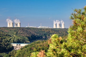 Summer landscape with dam, forest and nuclear power plant