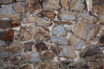 Grey stone wall of an old building, background texture of a brick