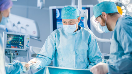 Shot in the Operating Room, Assistant Hands out Instruments to Surgeons During Operation. Surgeons Perform Operation. Professional Medical Doctors Performing Surgery.