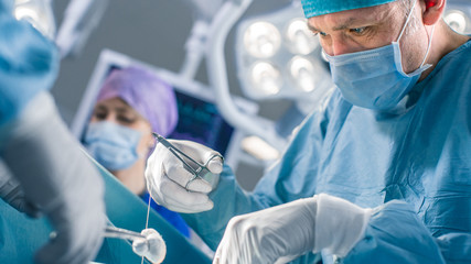 Close-up Shot of the Professional Surgeon Suture Wound after Successful Surgery. In the Background...