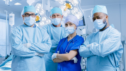 Diverse Team of Professional surgeon,  Assistants and Nurses Standing Proudly with Crossed Arms in the Real Modern Hospital with Authentic Equipment.