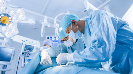Diverse Team of Professional surgeon,  Assistants and Nurses Performing Invasive Surgery on a...