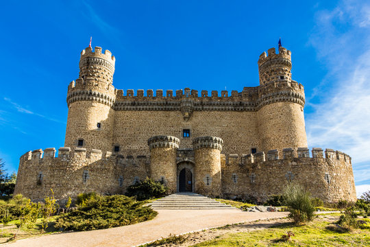 Facade of a medieval castle palace under a blue sky (Manzanares el Real, Spain)