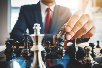 hand of businessman moving chess figure in competition success play. strategy, management or...