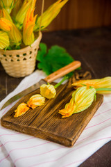 Obraz na płótnie Canvas Edible flowers, zucchini blossoms on brown natural background