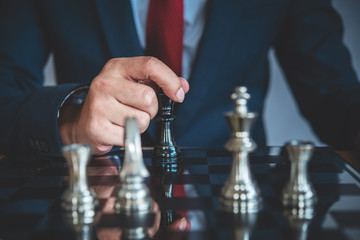 hand of businessman moving chess figure in competition success play. strategy, management or...