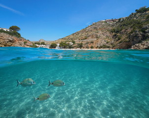 Fototapeta premium Spain Javea Cala Granadella beach with fish and sand underwater, split view above and below water surface, Mediterranean sea, Costa Blanca, Alicante, Valencia