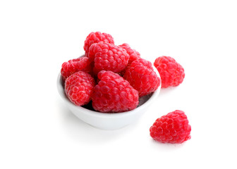 Bowl with ripe raspberries on white background