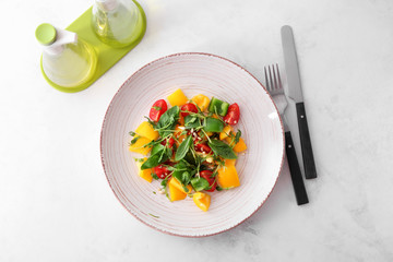 Plate with tasty vegetable salad on light table