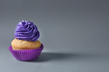 Delicious birthday cupcake on color background