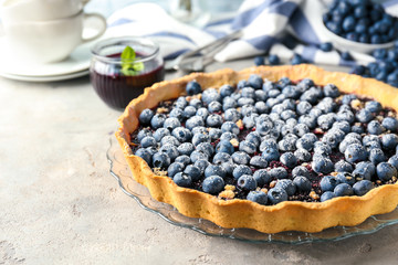 Plate with delicious blueberry pie on table
