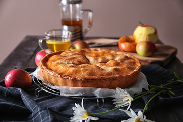 Cooling rack with delicious apple pie on table