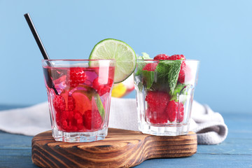 Glasses of fresh raspberry mojito on wooden table