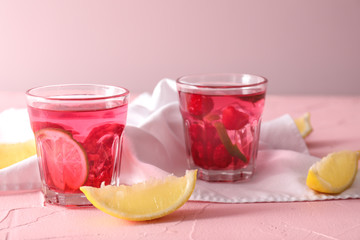 Glasses of fresh raspberry mojito on color table