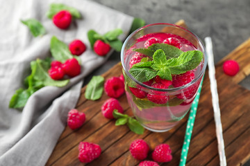 Glass of fresh raspberry mojito on board
