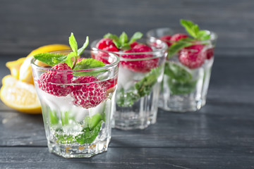 Glasses of fresh raspberry mojito on wooden table