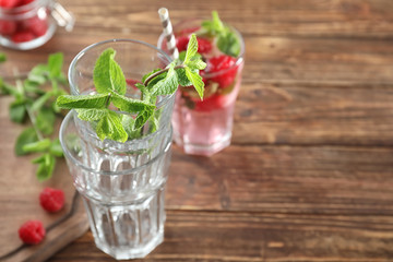 Empty glasses with mint leaves on wooden table