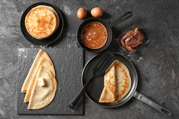 Composition with tasty thin pancakes and chocolate spread on table