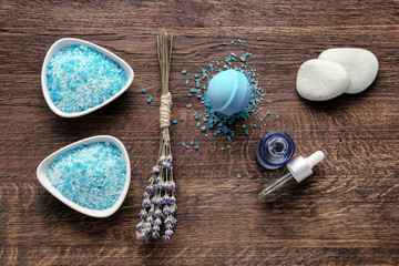 Spa composition with sea salt, cosmetics and lavender on wooden table