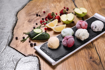 Slate plate with yummy ice cream and different ingredients on table