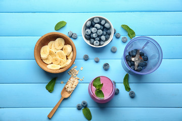Composition with tasty blueberry smoothie on color wooden background