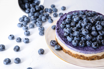 Plate with delicious blueberry cheesecake on white background