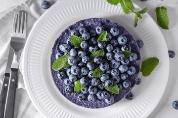 Delicious cheesecake with blueberries on plate, top view