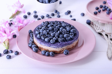 Plate with delicious blueberry cheesecake on table