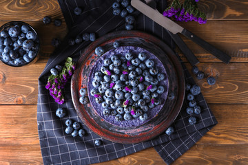 Plate with delicious blueberry cheesecake on wooden table