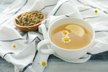 Cup of delicious camomile tea on wooden table