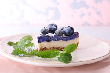 Piece of tasty cheesecake with blueberries on plate, closeup